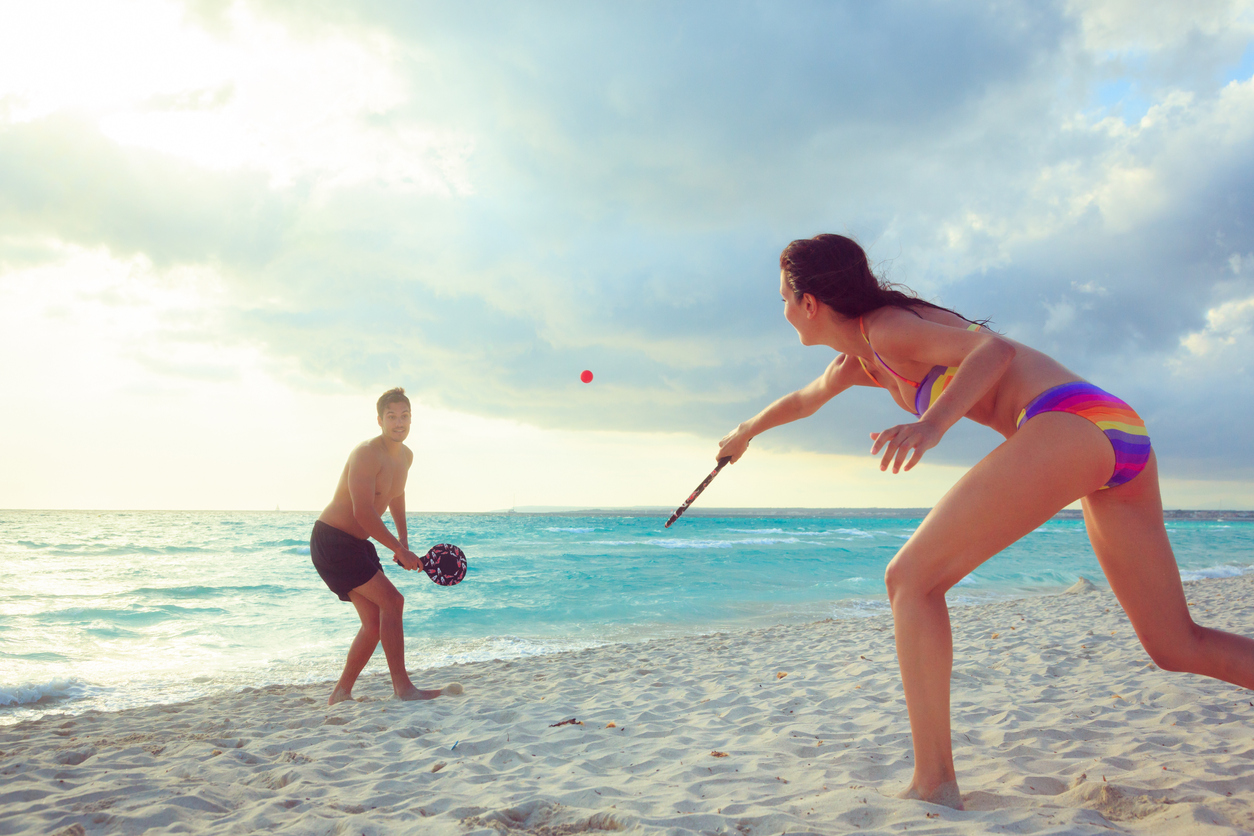 Jeune couple jouant au tennis de plage