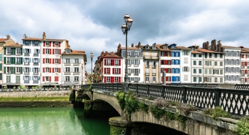 Les quais de Bayonne bordés de maisons aux volets colorés, avec un pont au-dessus de la Nive.