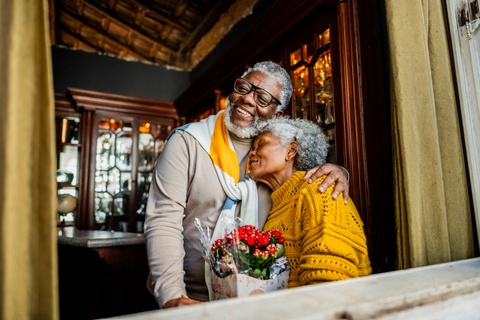 Mari offrant des fleurs à sa femme à la maison