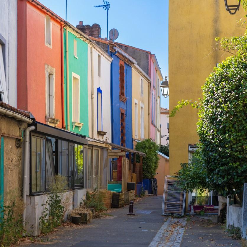 Une ruelle de Trentemoult bordée de maisons aux façades colorées.